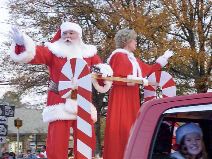 Santa and the Mrs. wave in last year's Fayetteville Christmas Parade. Staff photo.