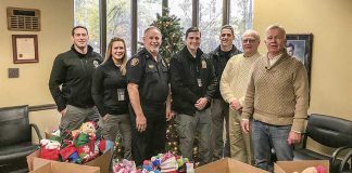 Carrying on a Peachtree City tradition of giving — Doing their part for the Peachtree City Police Department’s annual Light Up the Night Toy Drive for needy kids are, from left, department staff Ryan MacCallum, Heather Scott, Stan Pye, Steven Stoyell and Gary Meier, joined by Beechwood subdivision residents Jerry Neese and Denny Spaulding, who have carried on the practice of supplying Christmas stocking for needy kids, an effort started in the early 1990s by the late David Hanahan. Photo/Peachtree City Police Department.