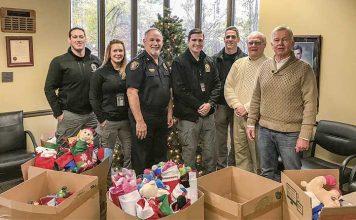 Carrying on a Peachtree City tradition of giving — Doing their part for the Peachtree City Police Department’s annual Light Up the Night Toy Drive for needy kids are, from left, department staff Ryan MacCallum, Heather Scott, Stan Pye, Steven Stoyell and Gary Meier, joined by Beechwood subdivision residents Jerry Neese and Denny Spaulding, who have carried on the practice of supplying Christmas stocking for needy kids, an effort started in the early 1990s by the late David Hanahan. Photo/Peachtree City Police Department.