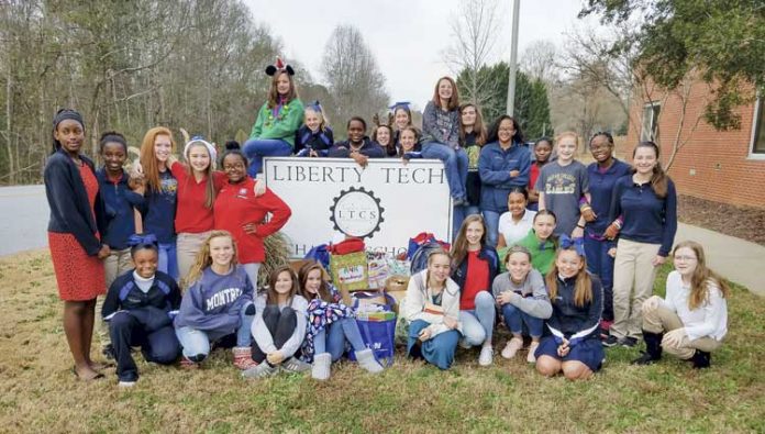 Posing in front of the school sign a year ago are some of the numerous students at Liberty Tech Charter School in Brooks who formed an “Ambassadors 4 Kids” club to prevent bullying. Photo/Submitted.