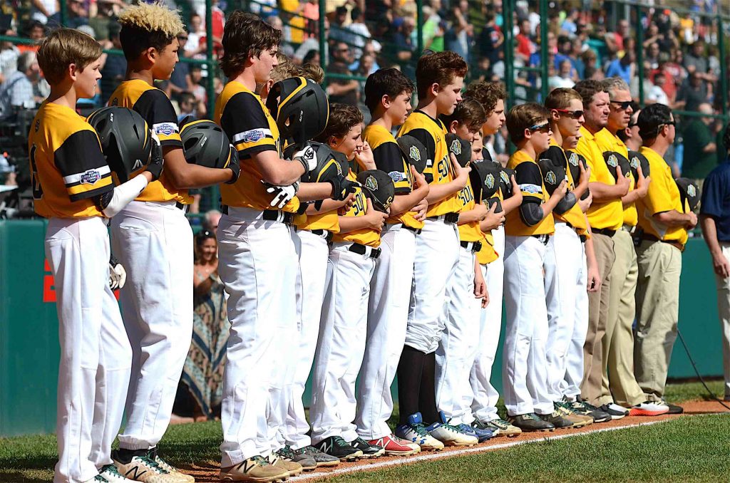 Peachtree City Little League players stand on the foul line during the National Anthem before the United States Championship in Williamsport, PA. 