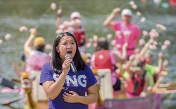 Anna Seville sings “You Lift Me Up” at the edge of the Lake McIntosh pier Saturday afternoon during festivities for the annual Rotary Club Dragon Boat Races. Photo/Markus Schwab Photography.