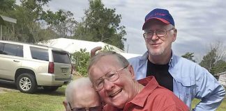Senoia resident Bob Lisle (in red shirt) gives his biological father, 88-year-old Floyd Sheffield, a hug as the two meet for the first time in March in Winterhaven, Fla. Standing nearby is Bob’s brother, Jeff Sheffield. Photo/Submitted.