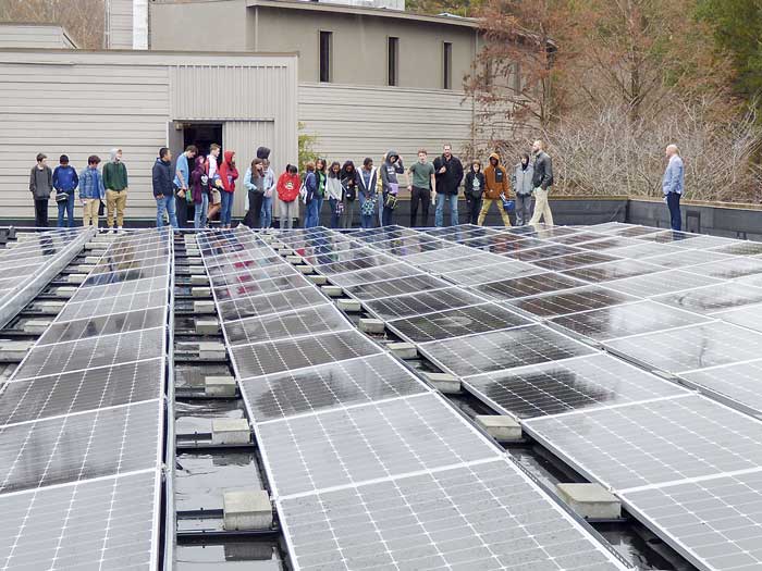 McIntosh High School students stand next to the massive rooftop power array. Photo/Ben Nelms.