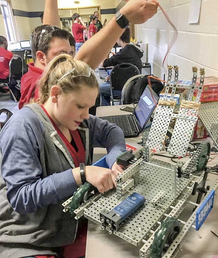 Whitewater High student Catie Hayes does some last minute prep work to get one of the VEX robots ready for competition. Photo/Fayette County School System.