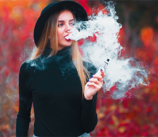 Shutterstock image of woman holding a vaping device.