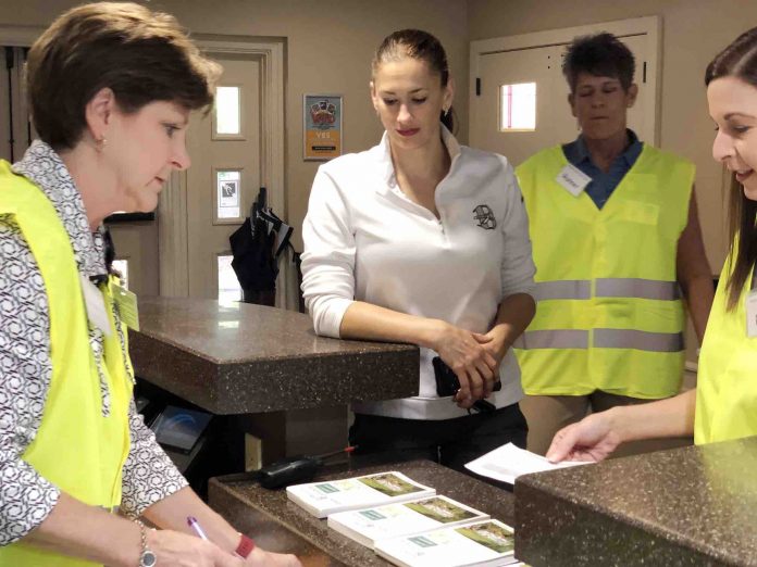 Parent Rebecca Norton (2nd from left, in white blouse) goes through a second identification check point before reunification with her child. Assisting with the check are (L-R) Renee Hammer, human resources assistant director; Norton; Deb Troutman, mathematics coordinator; and Jennifer Battles, certification officer in human resources. Photo/Fayette County School System.