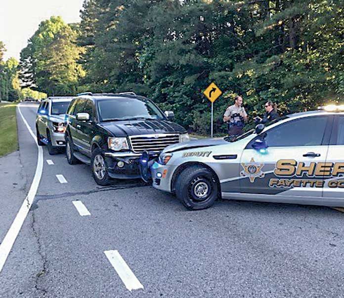 The suspects’ vehicle is shown sandwiched between two vehicles of the Fayette County Sheriff’s Department.