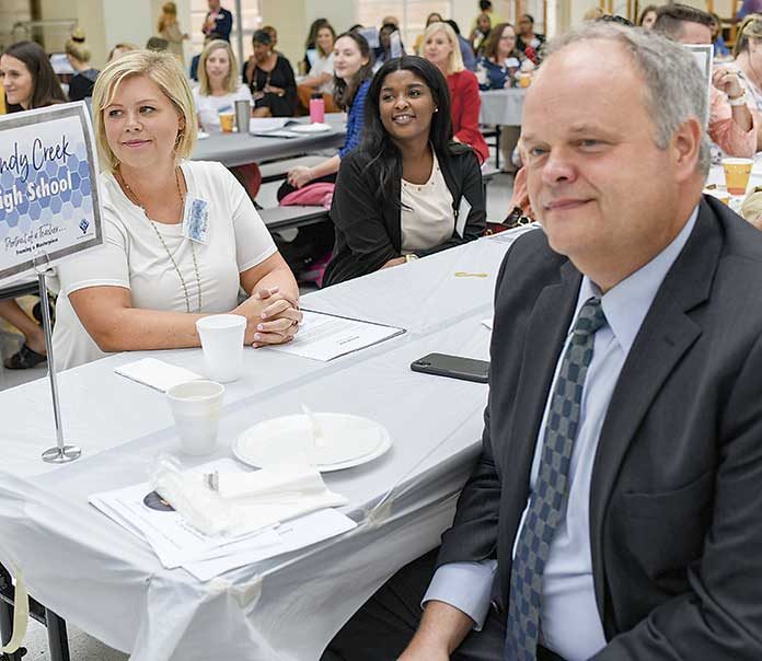 Sandy Creek High teacher Laura-Leigh Reynolds sits across from interim principal Richard Smith as they listen to Kim Herron, director of elementary education, deliver the first welcoming remarks to kick-off the 2019 New Teacher Induction. Photo/Fayette County School System.