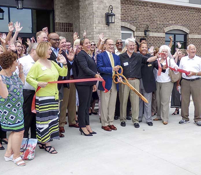 Among the large group at the June 27 grand opening for the HearthSide Club Lafayette active senior apartments in Fayetteville were, at center, Ga. Department. of Community Affairs Housing, Finance and Development Director Jill Cromartie, OneStreet Residential Senior Managing Partner David Dixon, project architect Bill Foley and Fayetteville Mayor Ed Johnson. Photo/Ben Nelms.