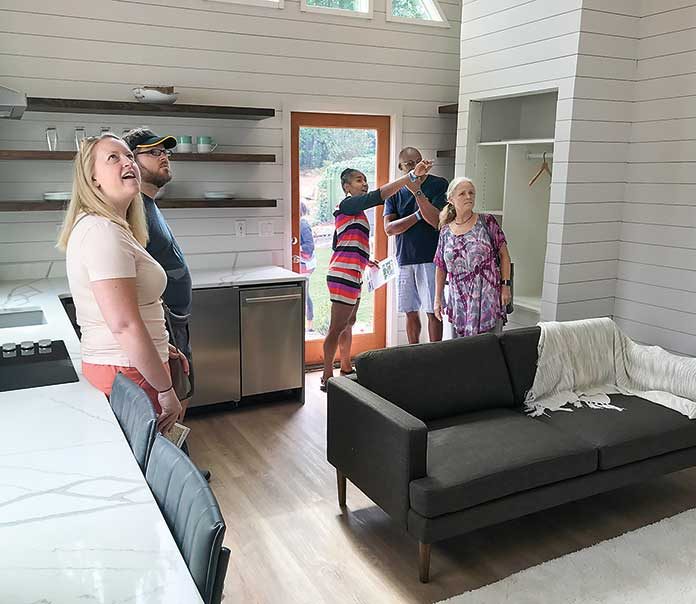 Visitors at the 536 sq. ft. “Peak” micro home at Pinewood Forest on July 20 got a look at a sampling of the smart home technology with which all six homes in the development’s first Micro Home Village are outfitted. Photo/Ben Nelms.