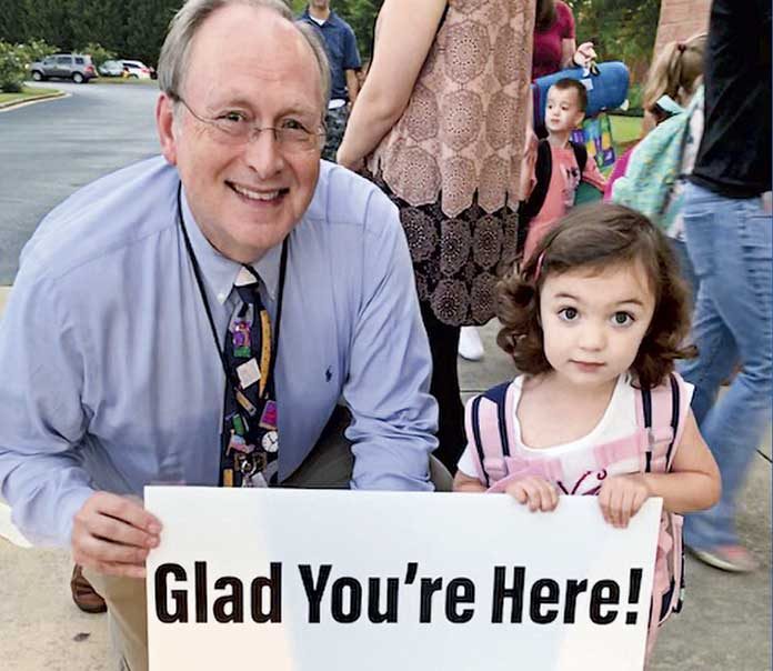 Fayette County Public School Superintendent Dr. Joseph Barrow holds a positive sign with Lillian, a preschooler at Cleveland Elementary. Photo/Fayette County School System.