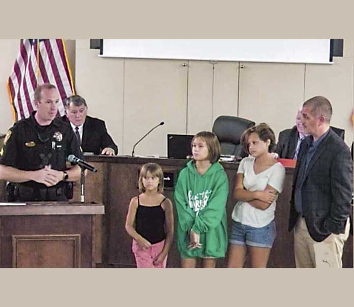 At right, in foreground, (L-R)Sgt. Chris Hyatt; Sarah, 6; Rachel, 10; Christina, 13; and father, Daniel Handley. Photo/Peachtree City.