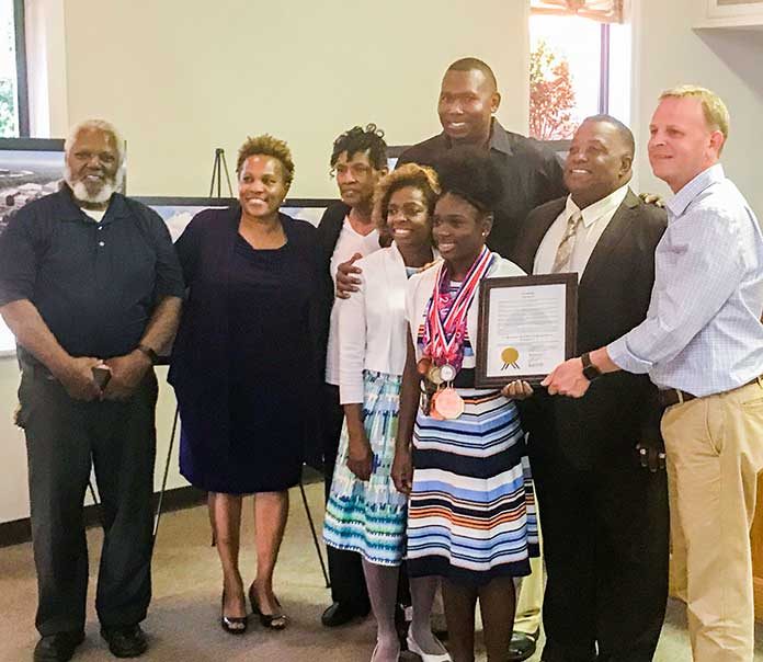 Flat Rock Middle School athlete was honored Sept. 5 by the Tyrone Town Council. Pictured with Noelle, in front, and her coach Rex Willis, second from right, and Mayor Eric Dial, at right, were members of her family. Photo/Ben Nelms.