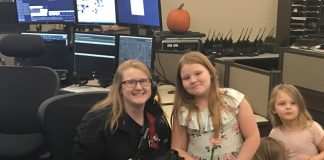 Fayette E-911 dispatcher Amber Heminger received an Oct. 14 visit from 9-year-old Delilah Austin, who called in a fire at her home on Oct. 11. Pictured, from left, are Heminger, Delilah and her sisters Isabella and Daniella. Photo/Ben Nelms.
