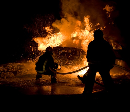 Shutterstock photo of firefighters at vehicle blaze.