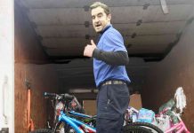 Warehouse employee Chase Callahan gives a big thumbs up as he loads bicycles inside his delivery truck. The bicycles are fulfilling the wishes of students included in this year’s CARE Angel Project. Photo/Fayette County School System.