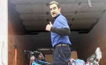Warehouse employee Chase Callahan gives a big thumbs up as he loads bicycles inside his delivery truck. The bicycles are fulfilling the wishes of students included in this year’s CARE Angel Project. Photo/Fayette County School System.