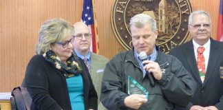 The retirement of longtime Fayette County Finance Department Director Mary Parrott was recently announced. Pictured with Parrot, at left, receiving an award for her service was County Administrator Steve Rapson. In the background were Commissioner Edge Gibbons and Chairman Randy Ognio. Photo/Ben Nelms.