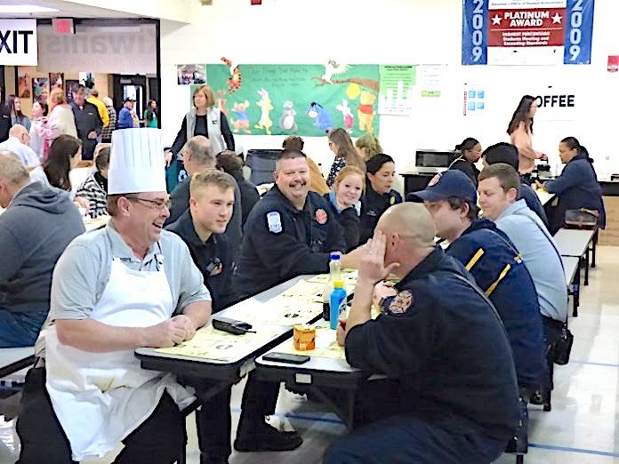 One of the chefs at the 29th Annual Pancake Breakfast held Jan. 25 at McIntosh High School took time to sit with firefighters enjoying a meal. As it turns out, the chef looks a lot like Peachtree City Fire Chief Joe O’Conor. Photo/Ben Nelms.