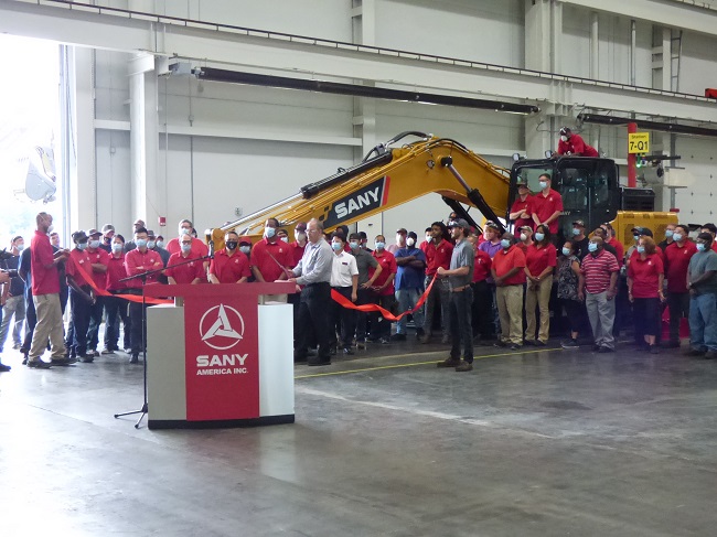 The manufacturing team at SANY America in Peachtree City was recognized June 24 for their efforts in completing the company's 100th SY215C excavator. The team is assembled in front of the large machine. Photo/Ben Nelms.