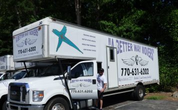 A Better Way Movers Office Manager John Kidney with one of the signature moving trucks at the company's Peachtree City location on Dividend Drive. Photo/Ben Nelms.
