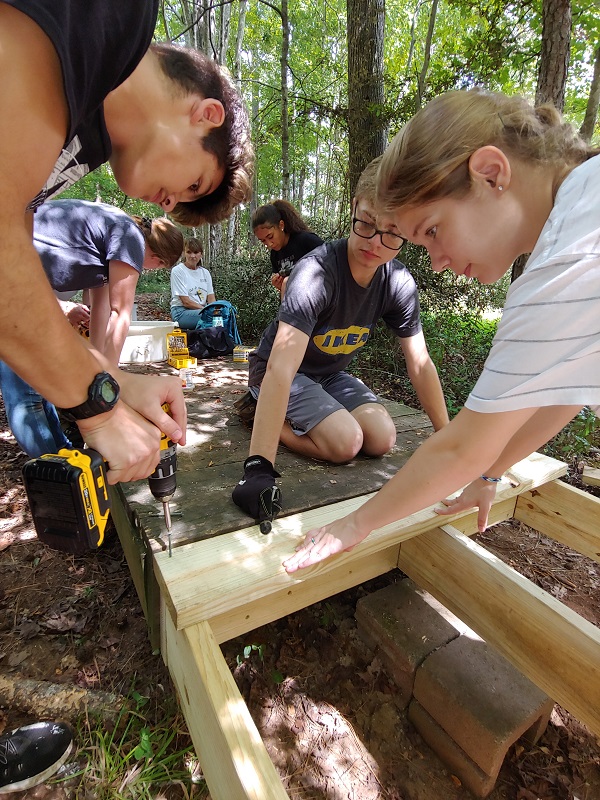 Freshmen at The Foundry high school in Peachtree City lend a helping hand on a variety of projects at the Calvin Center in Hampton. Photo/Submitted.