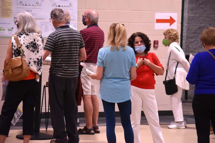 Peachtree City Mayor Vanessa Fleisch (in red facing camera) hears from a resident during the LCI Open House Oct. 22 at Kedron Fieldhouse. Photo/Cal Beverly.