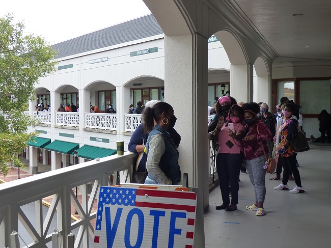 <b>The Fayette County Elections Office in Fayetteville had people lined down the upstairs walkway, down the stairs and wrapped around part of the building as they waited to vote during the first day of voting on Monday. Photo/Ben Nelms.</b>