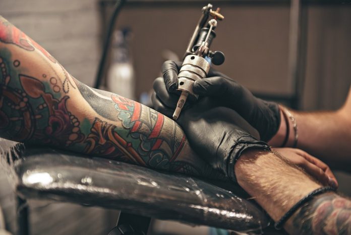 112220 Tattoo artist works on arm E