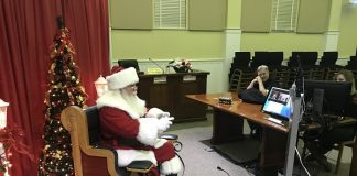 Santa stopped in at Fayetteville City Hall on Dec. 8 for a virtual visit with kids who wanted to make sure he knew all about their Christmas wishes. Sitting at the right were city IT staff Kelvin Joiner and Jessica Smith, who arranged the virtual visits. Photo/Ben Nelms.