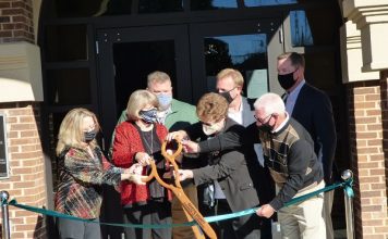Cutting the ribbon at the new Tyrone Municipal Complex on Dec. 10 were, from left, front row, council members Melissa Hill, Gloria Furr, Linda Howard and Billy Campbell; and from left in rear, Town Manager Brandon Perkins, Mayor Eric Dial and Fayette Chamber of Commerce CEO Colin Martin. Photo/Ben Nelms.