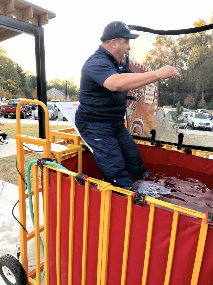 Fayetteville Mayor Ed Johnson’s Navy career came in handy Nov. 6 when he braved the chilly waters in the dunking booth at the city’s Carnival in the Park, held at City Center Park behind City Hall. The event had nothing to do with conducting city business. It was simply a matter of the good-natured mayor providing fun for the many kids that filled the park, who were honing their pitching skills and determined to have the adults land in the water. Photo/Ben Nelms.