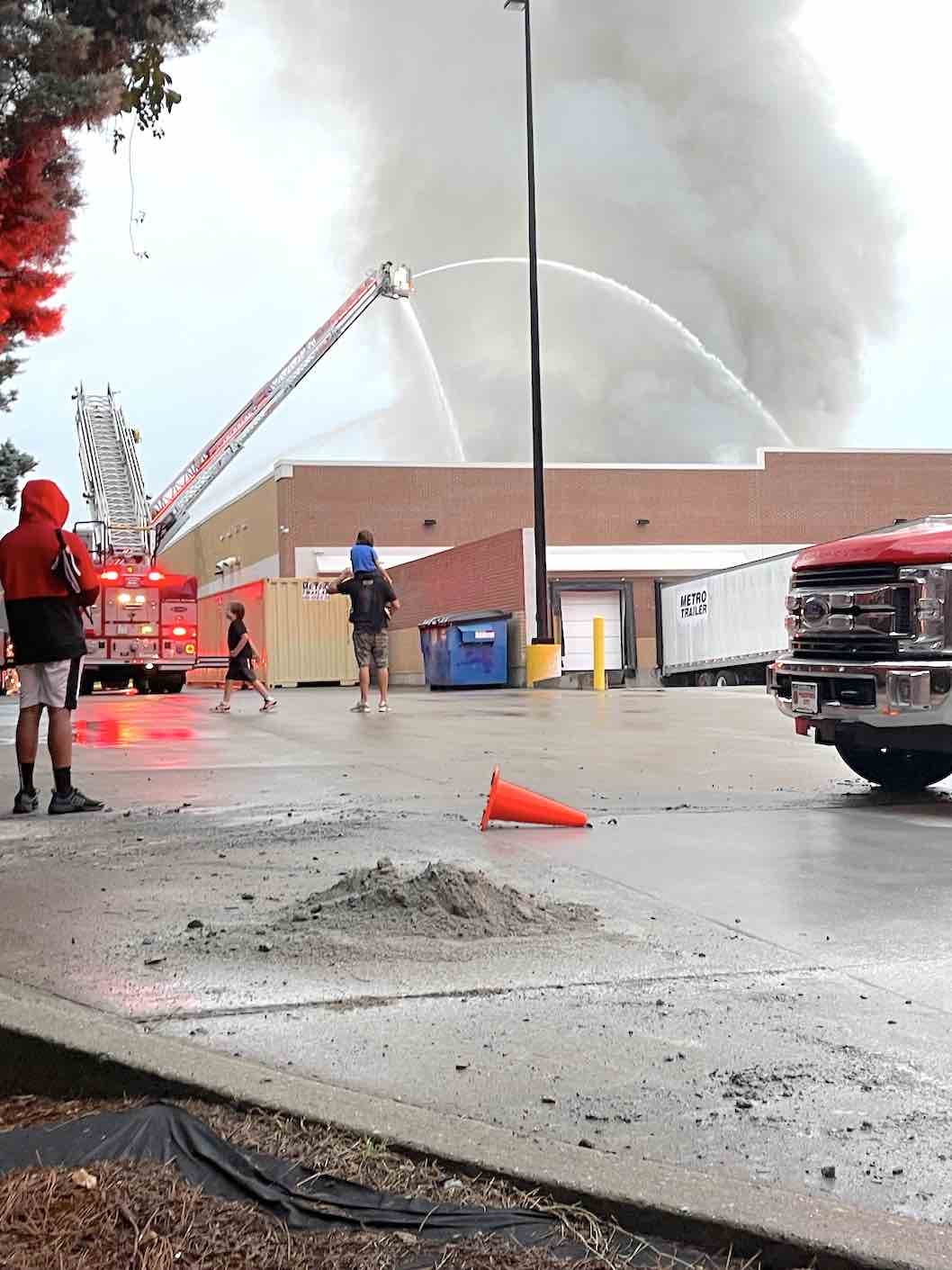 Civilians watch as firefighters pour water into the back-store blaze at Walmart. Photo by Carol Kurpiel.