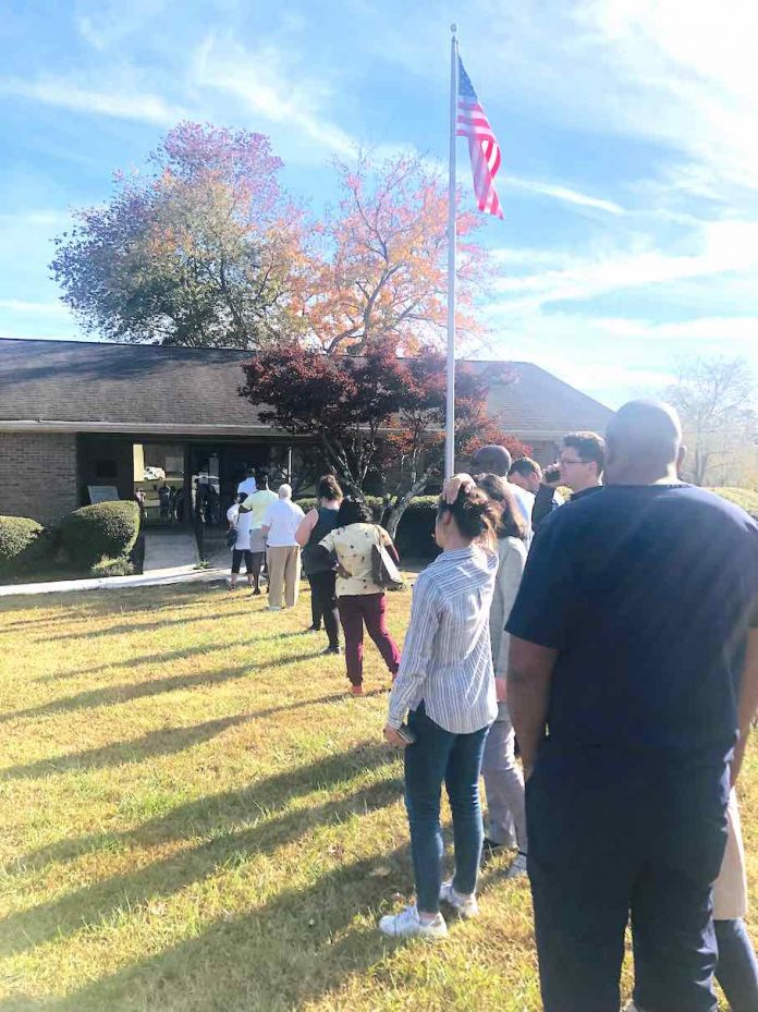 Waiting voters cast late Friday afternoon shadows as they queue up to cast ballots at the former Tyrone Police Department HQ. Photo/Joyce Beverly.