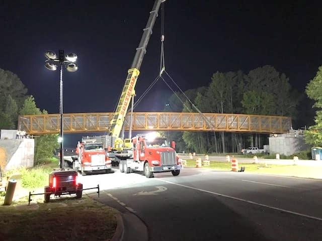 Crane lifts pedestrian bridge span into place. Photo/City of Fayetteville Facebook page.