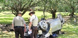 >Fayette County Sheriff's Office deputies examine a wrecked vehicle. Photo/FCSO.