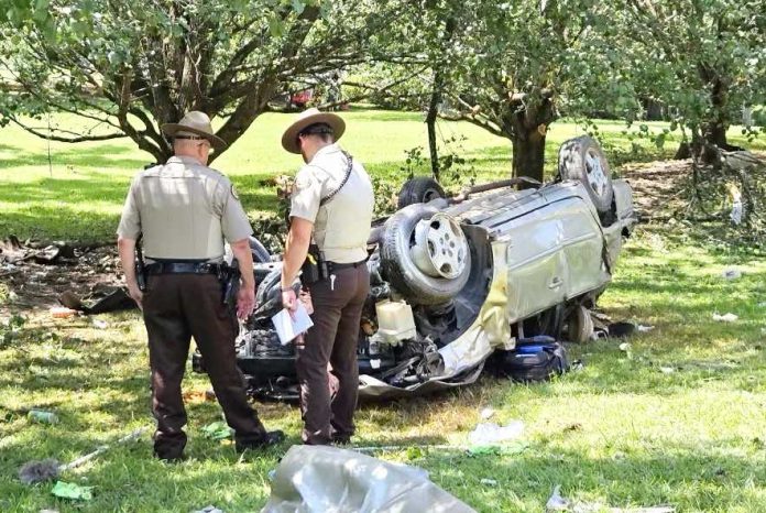 >Fayette County Sheriff's Office deputies examine a wrecked vehicle. Photo/FCSO.