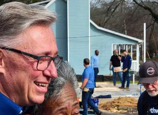 Ms. Derryl Anderson (with Rick Halbert) looks on as her new home receives finishing touches. Photo/City of Fayetteville, Ga.