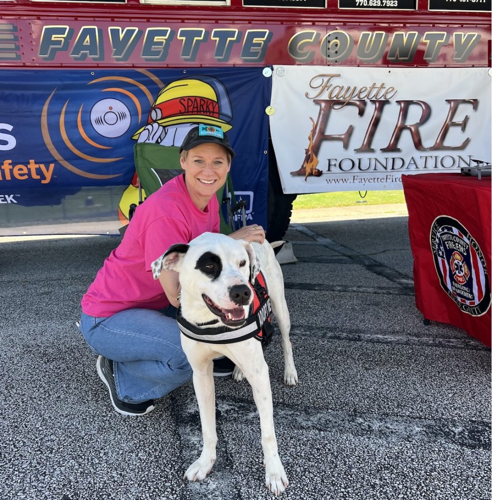 Mary Catherine Domaleski with Loki on his gotcha day last spring. It seemed appropriate to get his picture in front of the Fayette County fire safety bus. Photo/Joe Domaleski